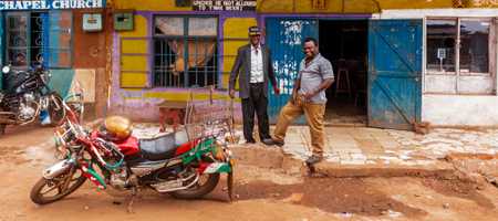 Two men smiling at the camera in Nairobi, outside of a restaurant.