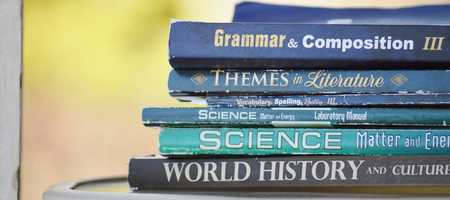 Stacked books. From top to bottom - Grammar & Composition 3, Themes in Literature, Vocabulary Spelling Poetry 3, Science Matter & Energy and World History & Culture.